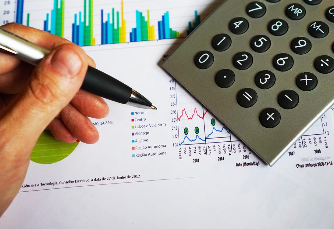 Calculator and printed charts representing ROI analysis