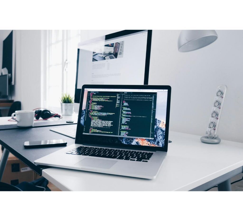 MacBook displaying code on a desk, representing custom headless ecommerce development